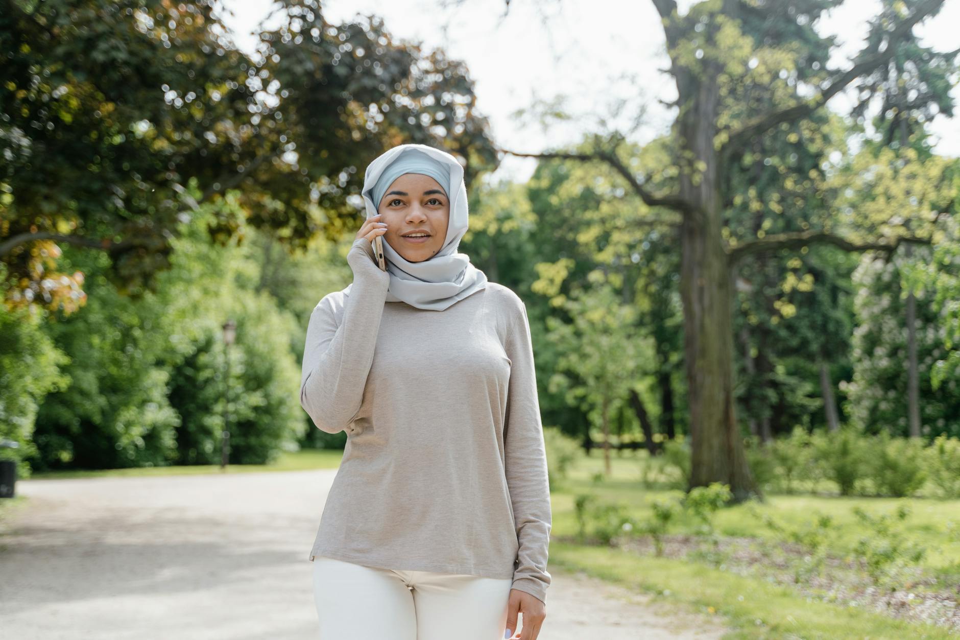 A person walking outdoors, casually speaking into their phone to capture a thought