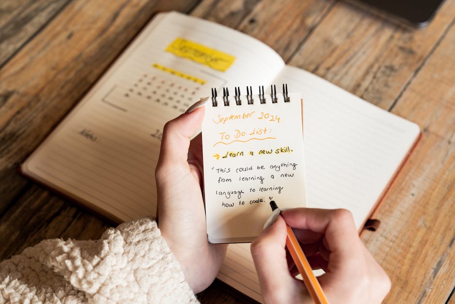 An open notebook with a short handwritten list on a warm wooden desk with soft natural light
