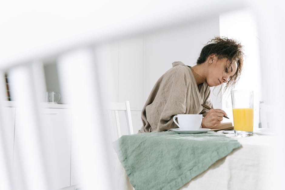A warm kitchen scene with a coffee cup and open notebook on a wooden table in soft morning light