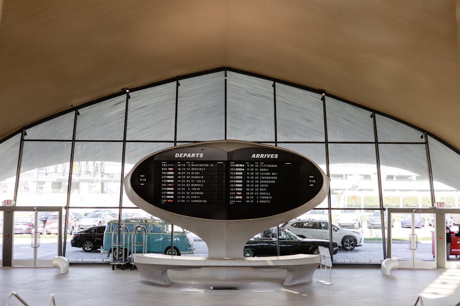 An airport terminal with a departure board showing upcoming flights