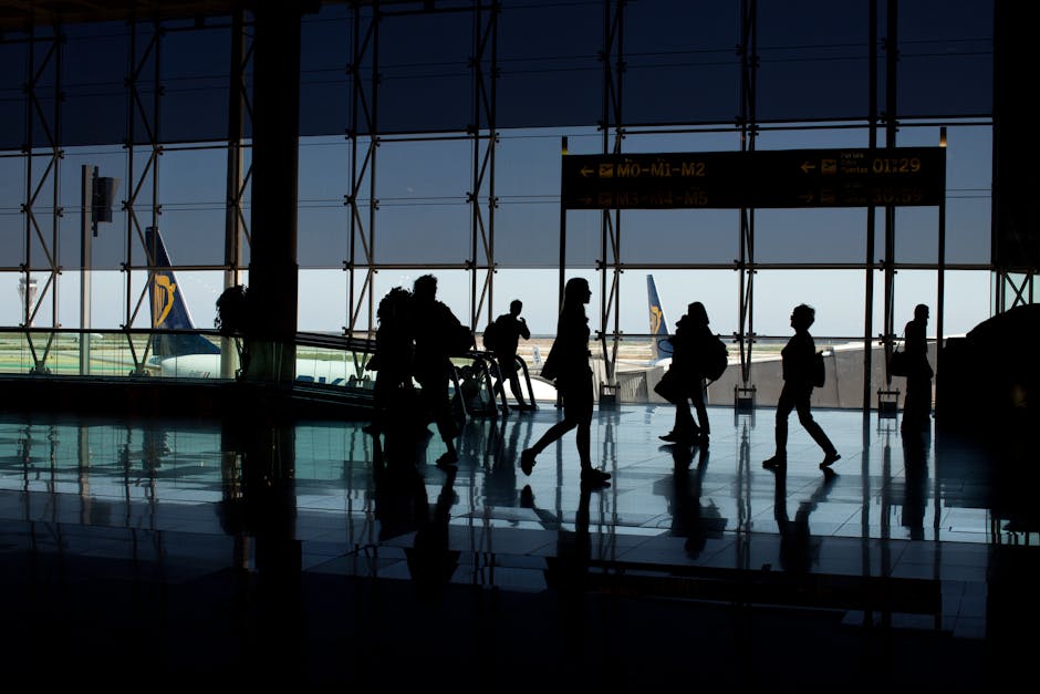 A traveler sitting at the airport gate, phone and boarding pass in hand