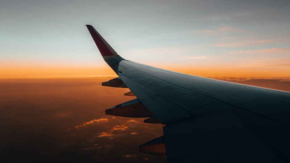 A breathtaking view through an airplane window — clouds lit by sunrise